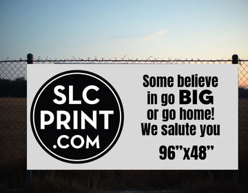 A picture of a 8x4 correx sign attached to a chain link fence, it has a logo and some words that say some believe in go big or go home! we salute you