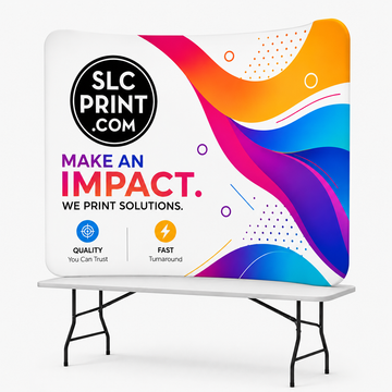 A curved tension display with colorful graphics on top of a table in front of a white background